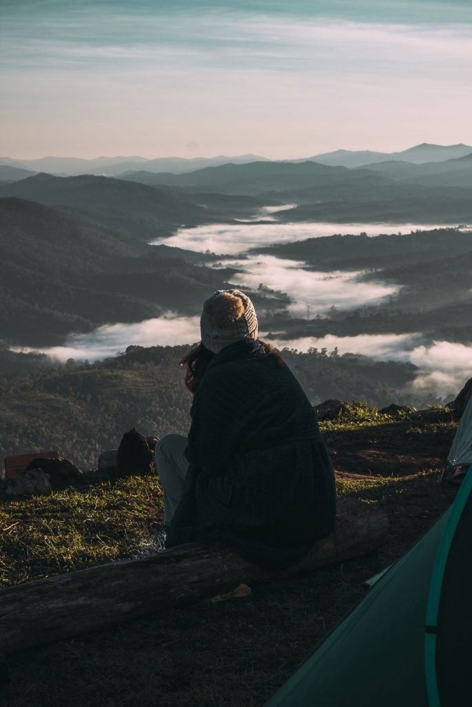 woman wrapped in blanket on mountain top